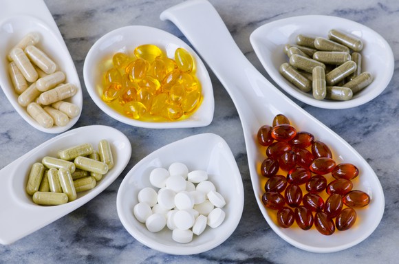 Nutrition supplements in bowls on a granite countertop.