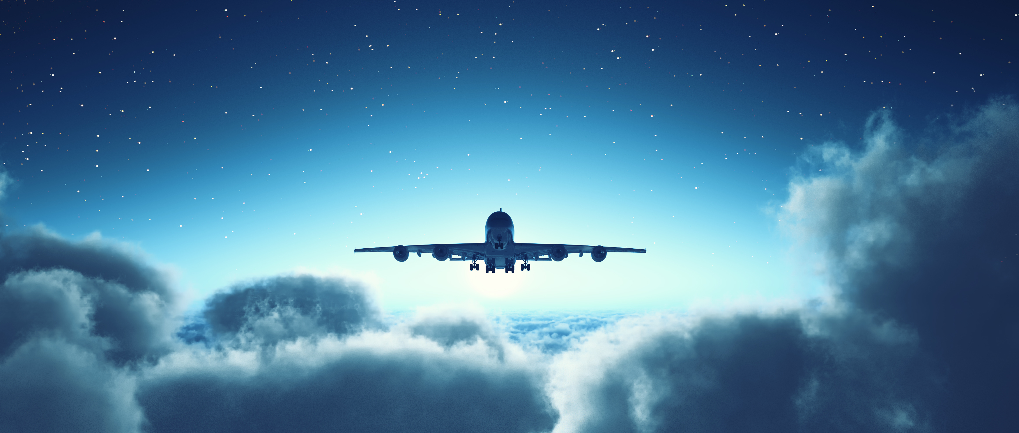 Aircraft flying above the clouds with a setting sun in the background.