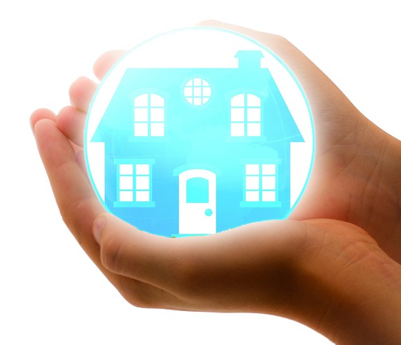 A house inside a bubble being held in someone's hands.