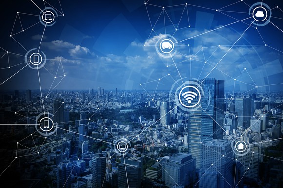 Image of city with lines drawn across it connecting to wireless devices.
