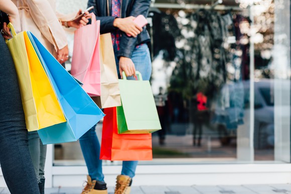 People carry colorful shopping bags.
