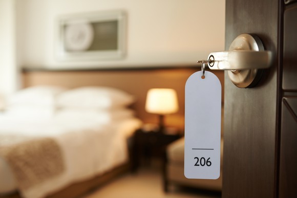 Hotel room door open, with key inserted in lock.
