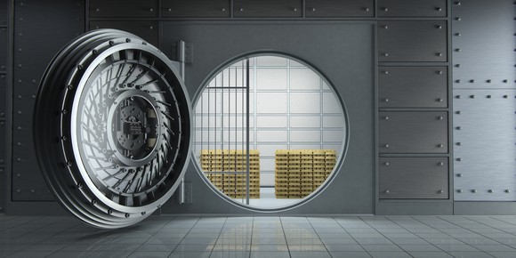 A bank vault with its door open and stacks of gold bars visible within