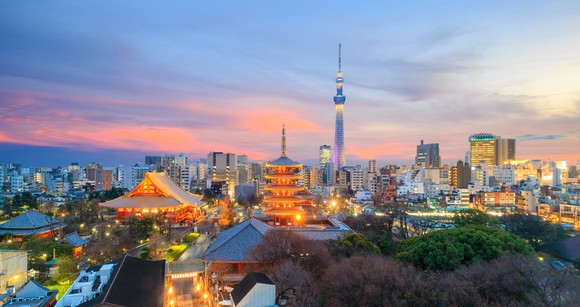 Colorful trees, a pagoda roofs, and the Tokyo skyline in the background
