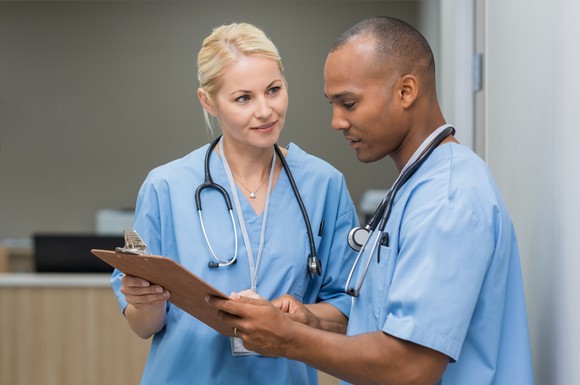 Man and woman in scrubs reviewing a chart