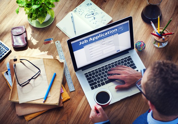 Man on a laptop filling out a job application.
