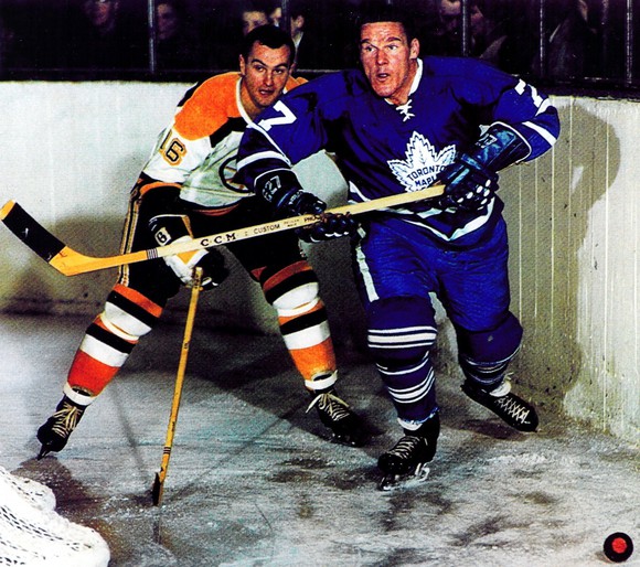 Tim Horton fights for the puck against an opponent.