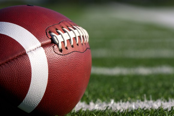 American football sitting on football field