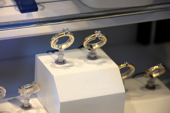 Two engagement rings in a glass case inside a jewelry store.