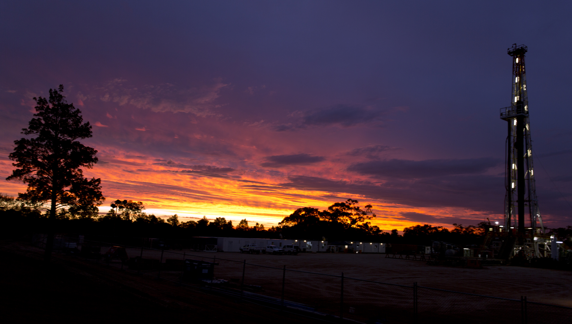 A land rig drilling at sunset.