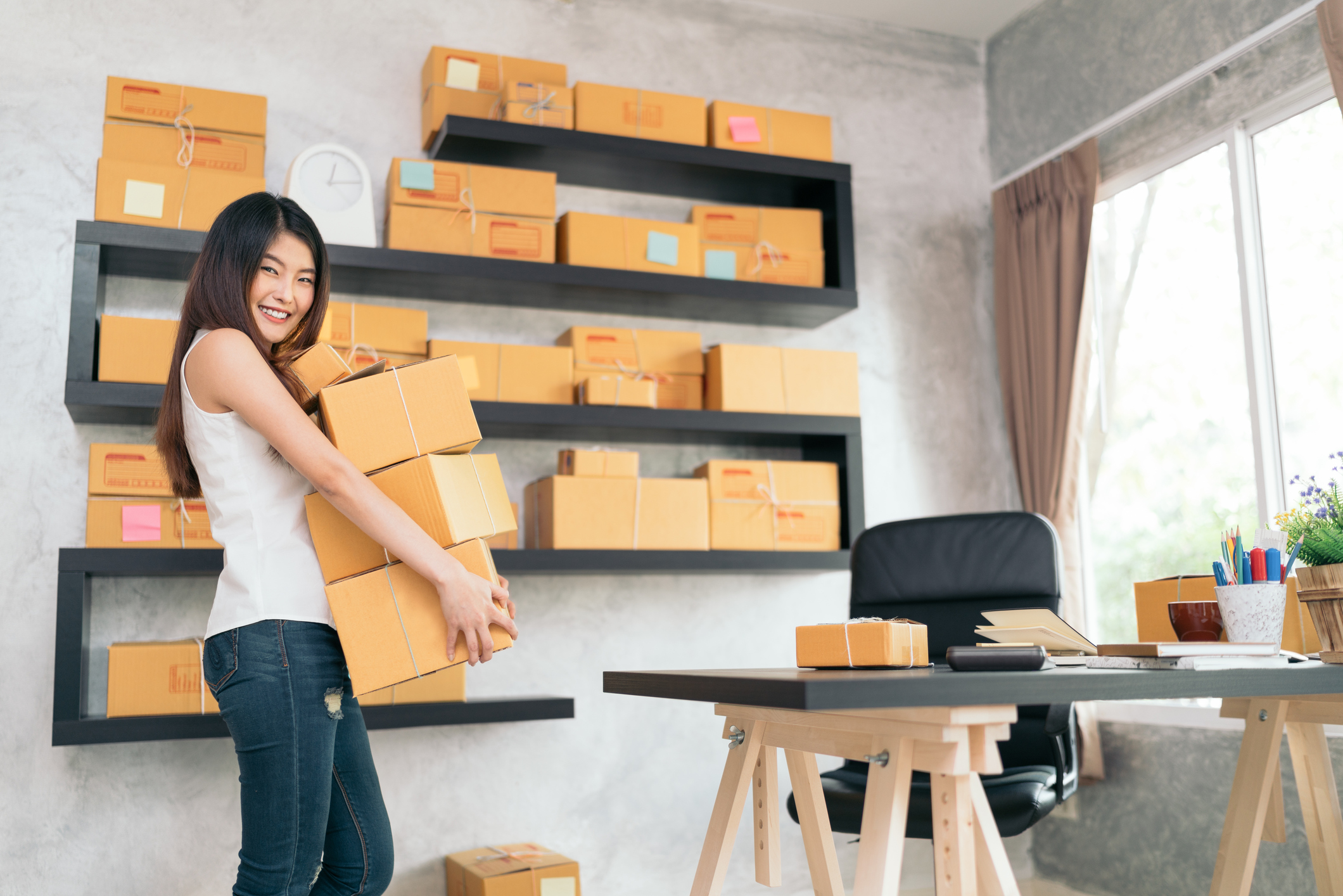 A young woman gets ready to ship parcels from her home.