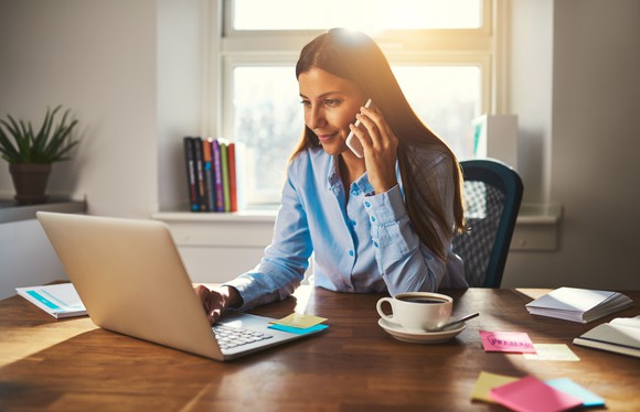 Woman at laptop talking on phone
