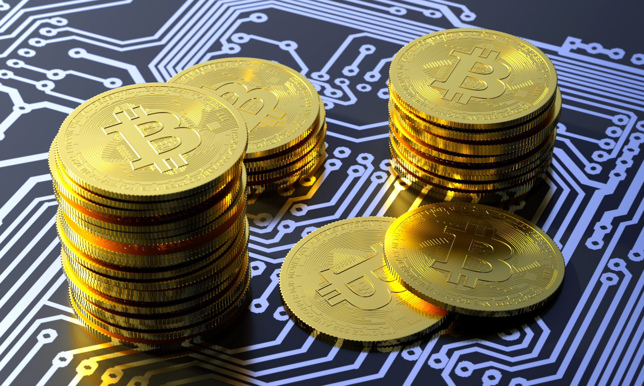 Several stacks of gold coins with the Bitcoin symbol on them sitting on a digital surface. 