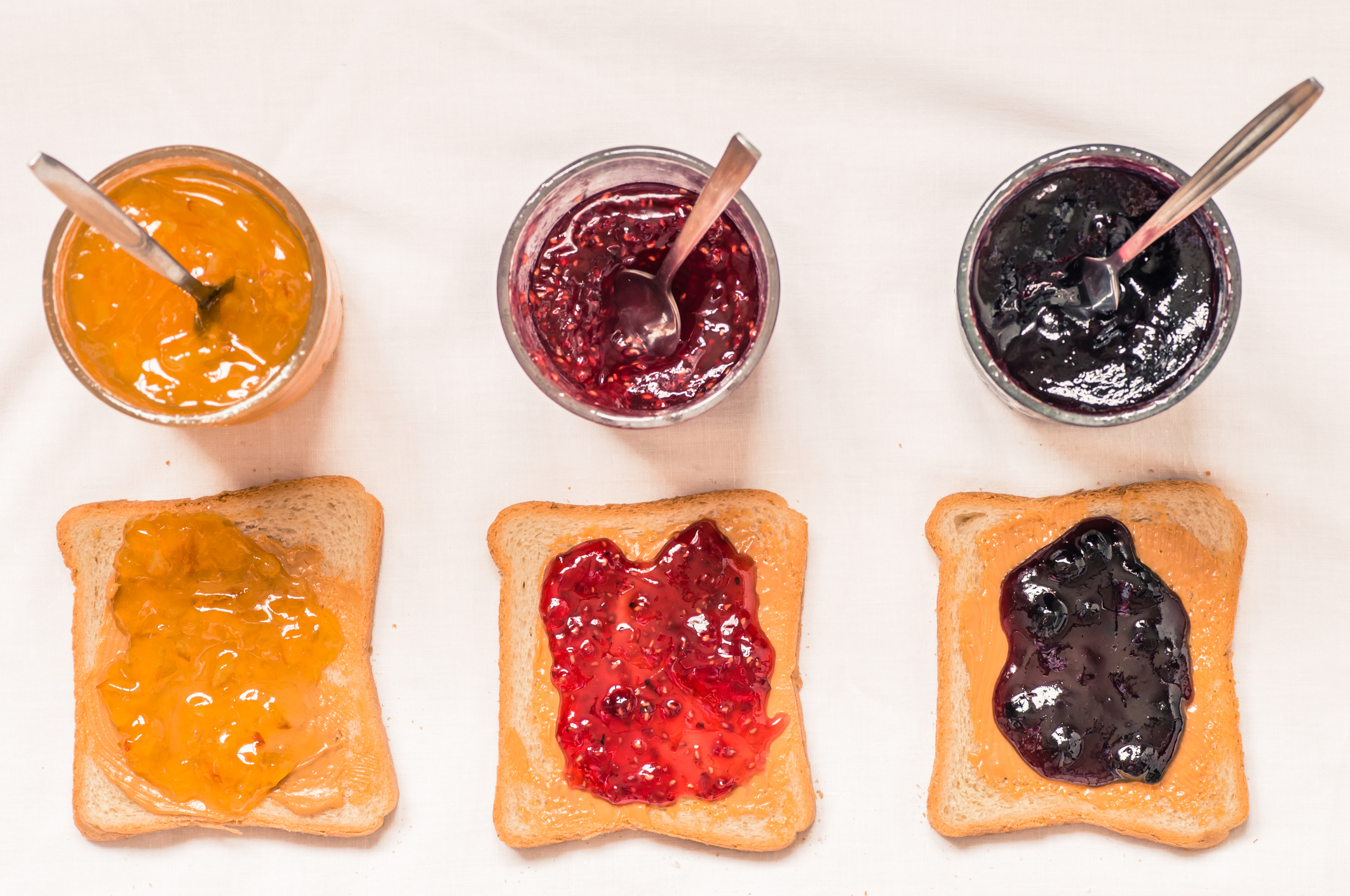 Three sandwiches with peanut butter and jelly.