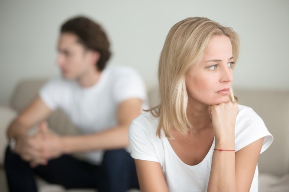 A woman looking upset with a man in the background