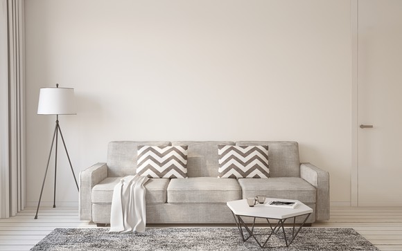 Lamp next to a tan couch and a small white table