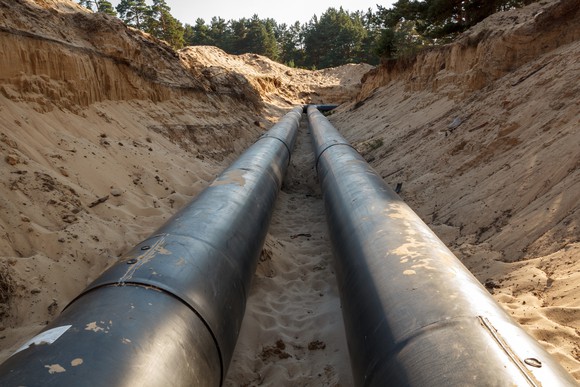 An uncovered pipeline construction site with sand around it