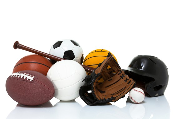 Sports equipment in a pile on the floor.