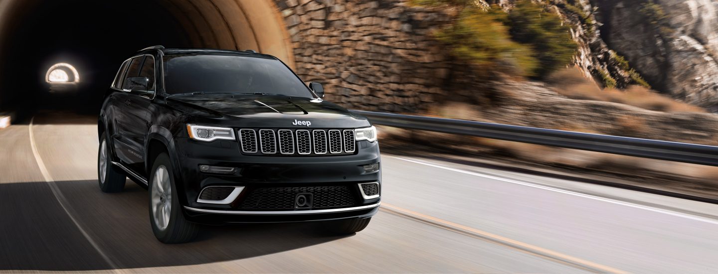 A 2018 Jeep Grand Cherokee driving out of a tunnel.
