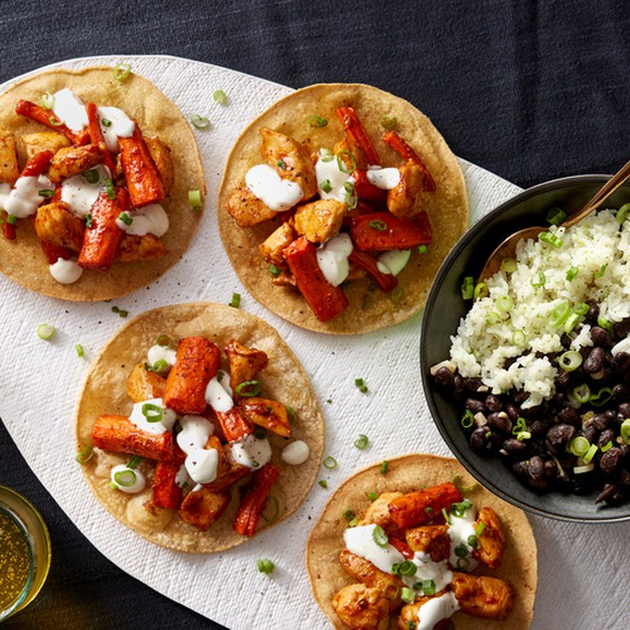 Several chicken tostadas shown on top of a large tortilla.
