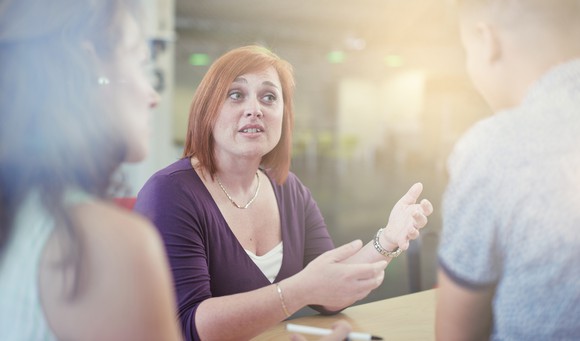 Woman speaking to another female and male