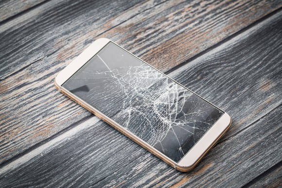 Broken smartphone sitting on table.
