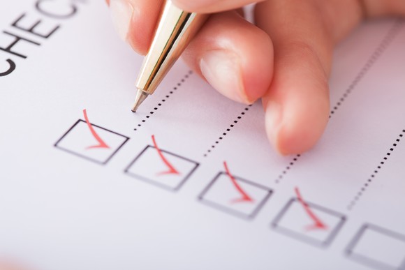 Hand with pen on checklist