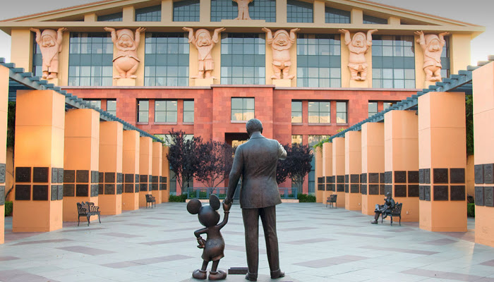 Satue of Wal Disney holding Mickey's hand from the back at Disney headquarters.