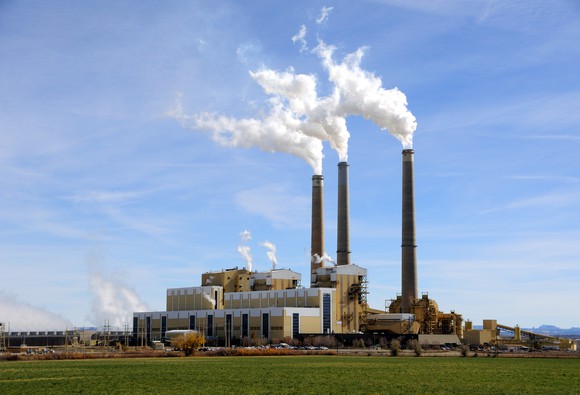 Coal power plant with smoke coming from smoke stacks. 