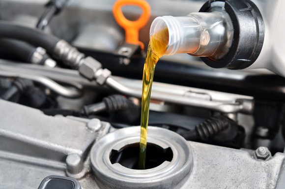Engine oil being poured into an engine.