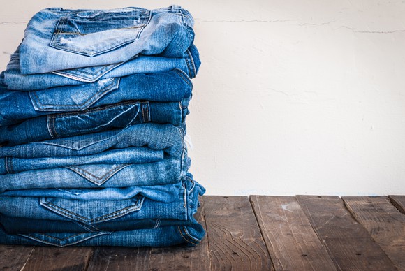 A stack of blue jeans on old wood