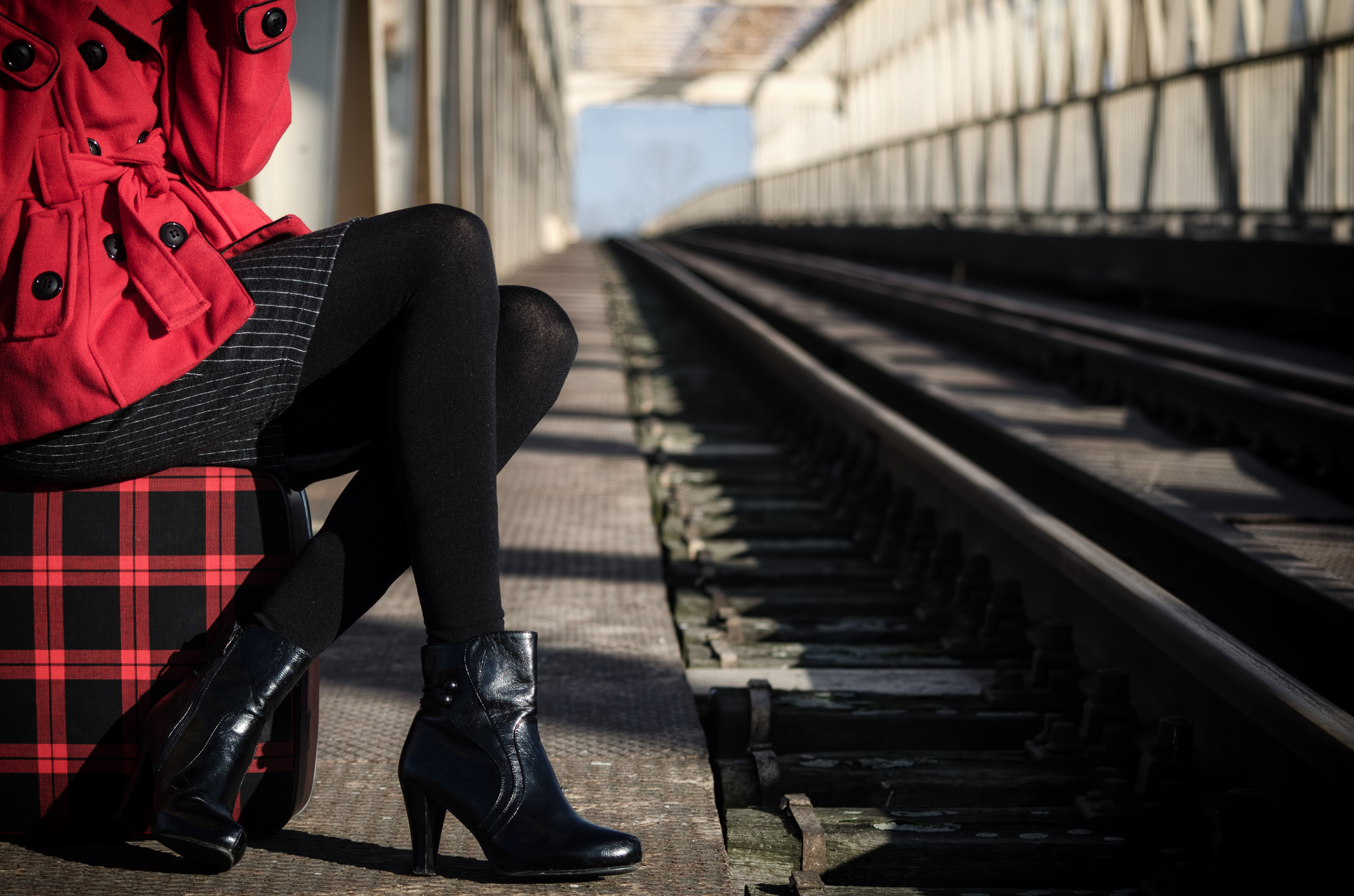 A well-dressed is seated in a train station.