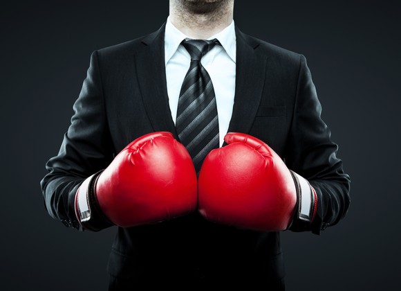 A man wearing a suit and boxing gloves.