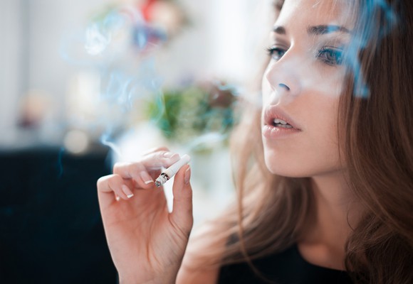 A woman smokes a cigarette.