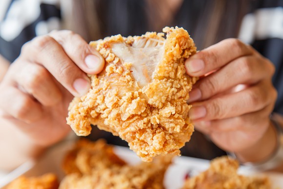 A man eating fried chicken.
