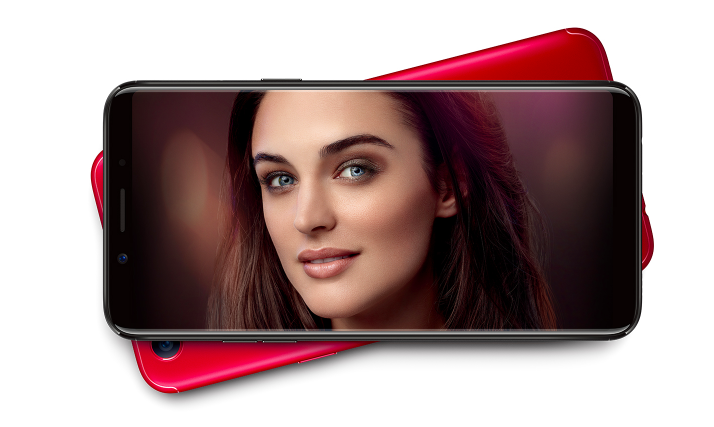 A close up of a black Oppo F5 phone with a picture of a woman's face on the screen.