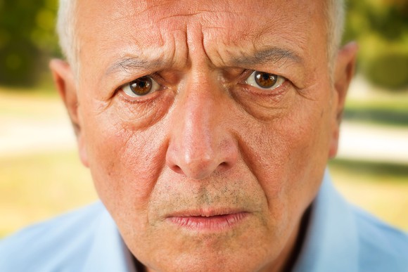Close-up of a senior citizen's face with an annoyed or worried look.