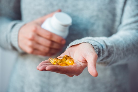 A hand holds out some pills