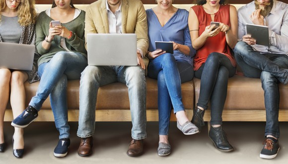 Young people look at laptops, tablets, and smartphones.