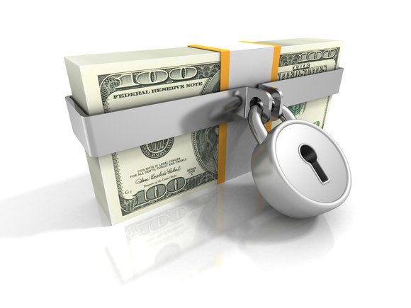 a stack of hundred dollar bills safeguarded with a padlock