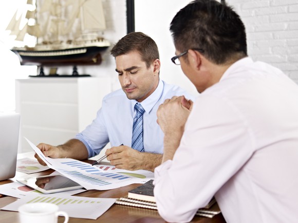 Two professionals reviewing paperwork at a desk