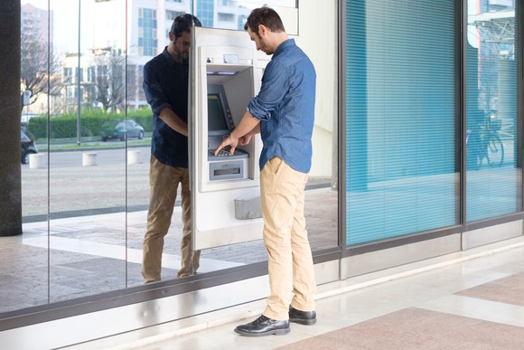 A man withdraws money from an ATM.