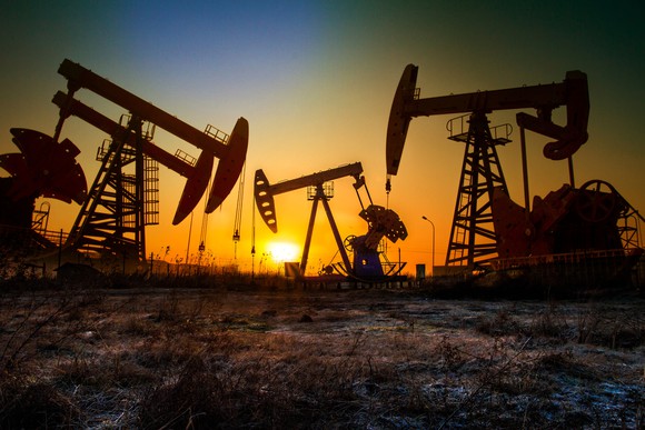 Drilling rigs in the plains at sunset.