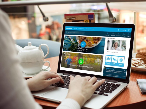Someone on a laptop checking out the Weight Watchers online management tool.