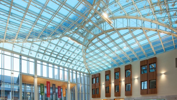 Blue glass ceiling with metal framing over a wide-open lobby space.