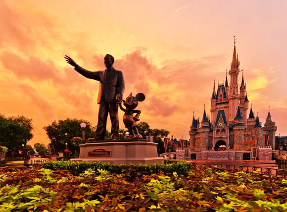 Statue of Walt Disney and Mickey Mouse in front of the Magic Kingdom castle at Disneyland.