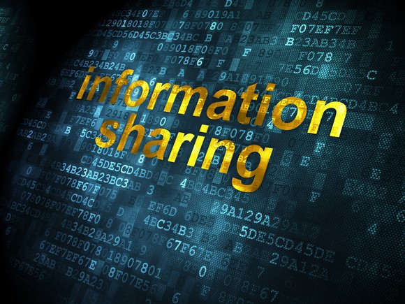 The words information sharing overlaid on digital code and a dark background.