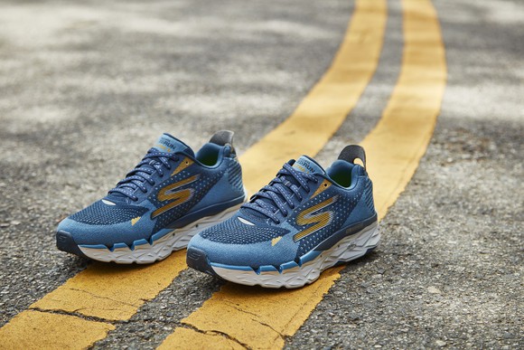 Pair of Skechers sneakers on a double yellow line in the middle of the road.