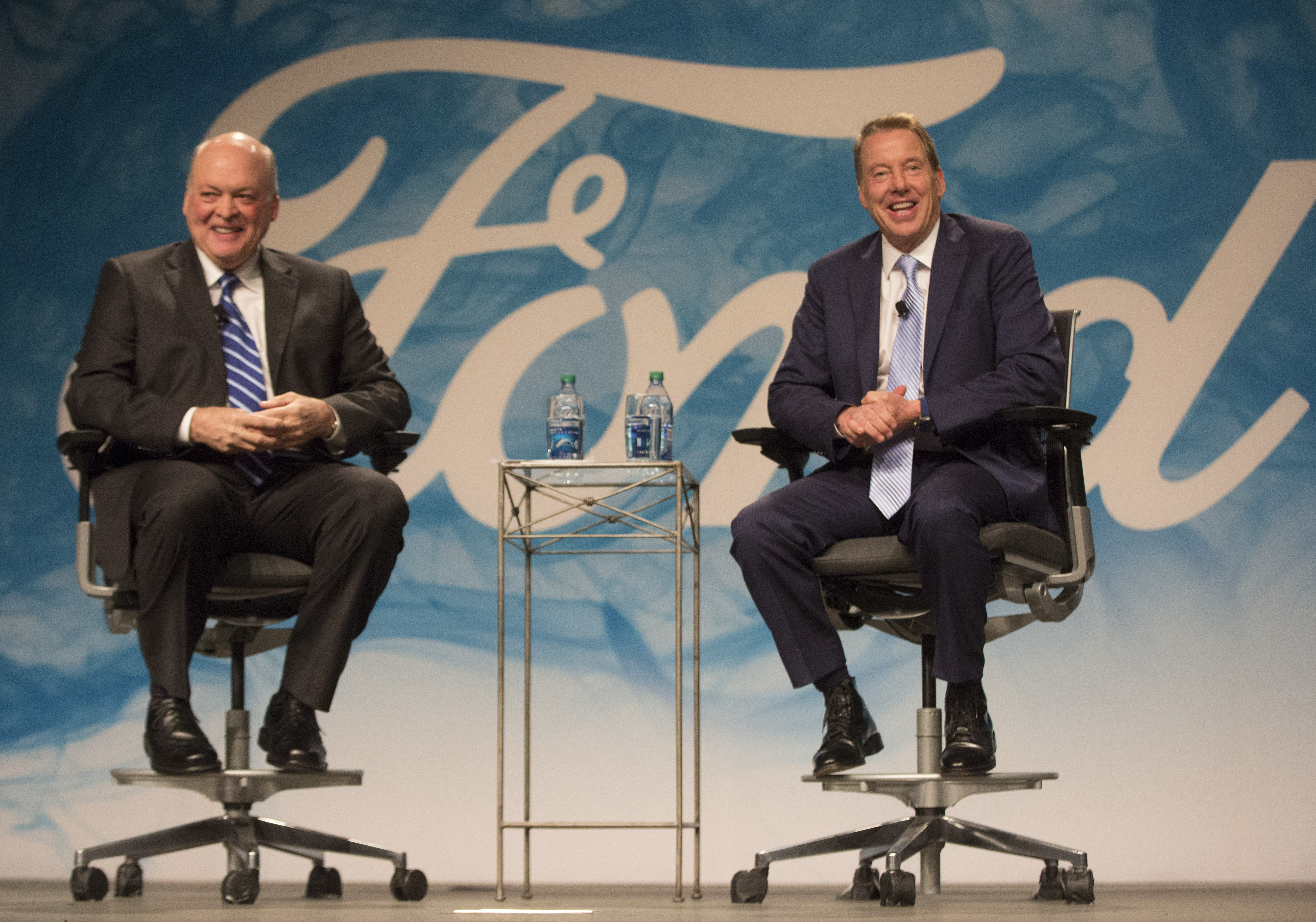 Jim Hackett and Bill Ford are shown seated before a large Ford-logoed backdrop.