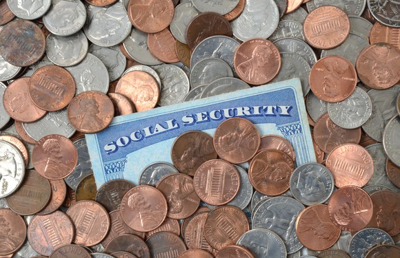 Social Security card half buried in U.S. coins.